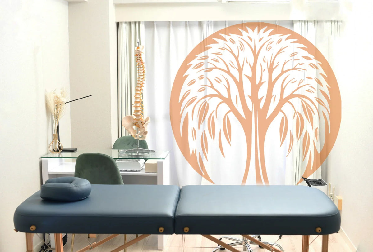 A professional acupuncture treatment room with a massage table and anatomical spine model.